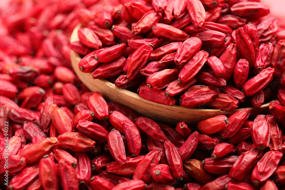 Spoon with dried barberries as background, closeup