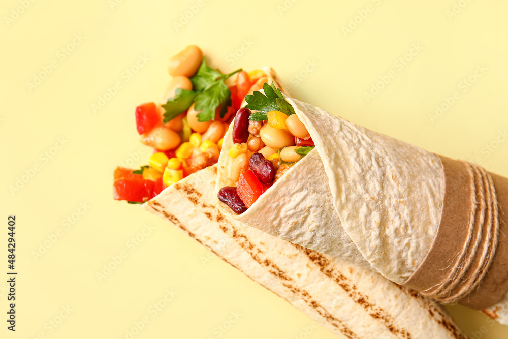 Delicious burritos on beige background, closeup