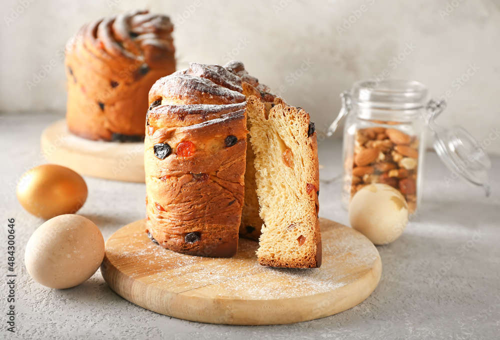 Wooden board with delicious Easter cake and eggs on table