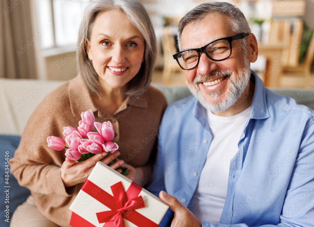 Loving    man husband giving  flowers and present gift box  for Valentines day   to happy wife