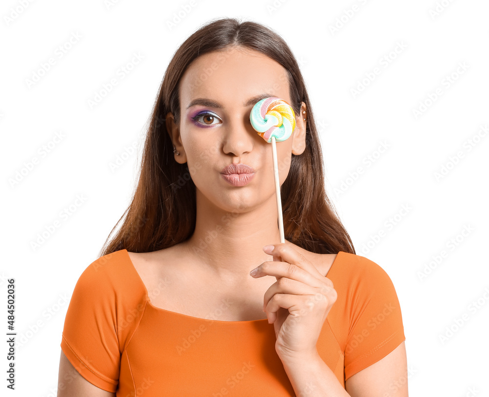 Young woman with lollipop blowing kiss on white background