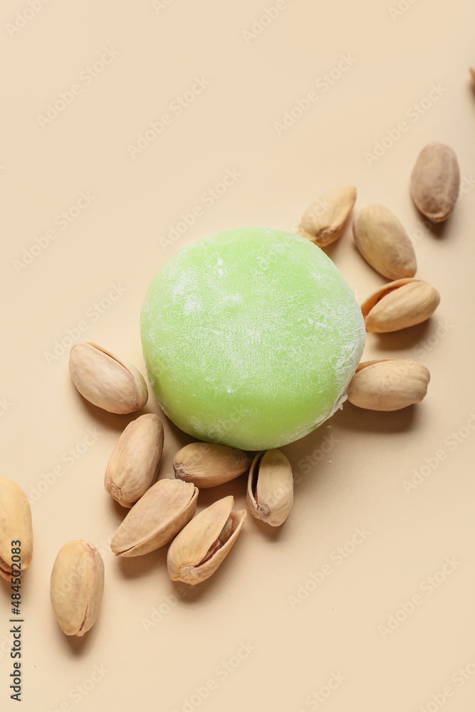 Delicious mochi and pistachios on light background