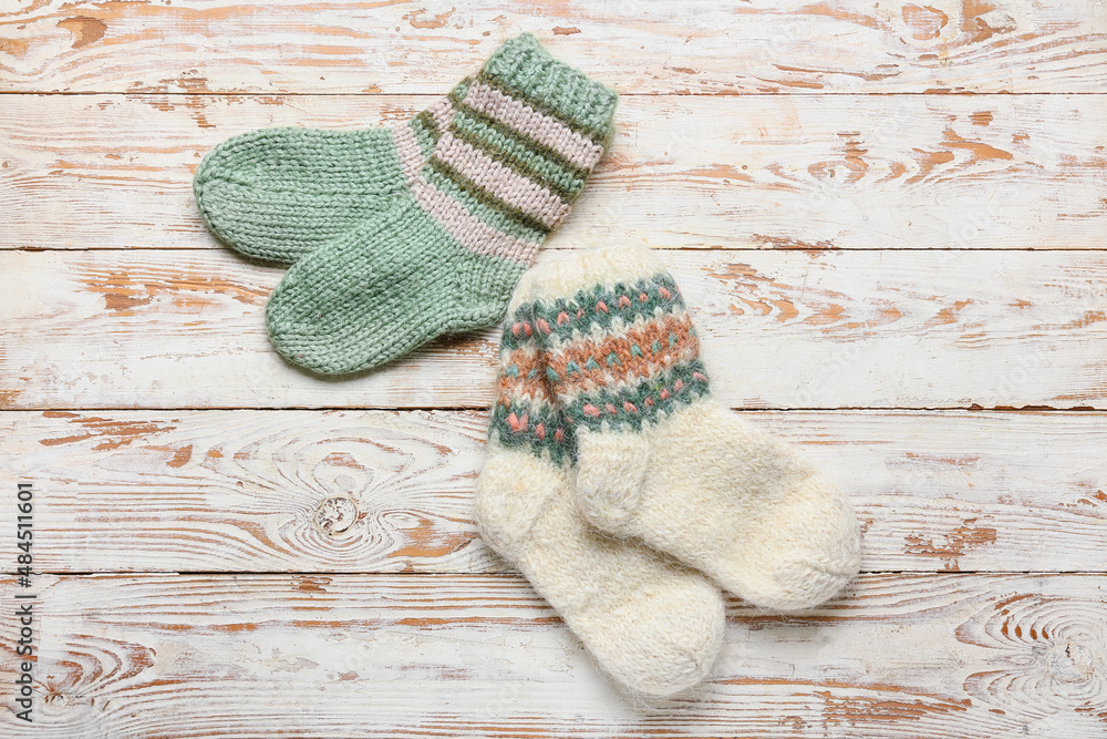 Knitted socks on light wooden background