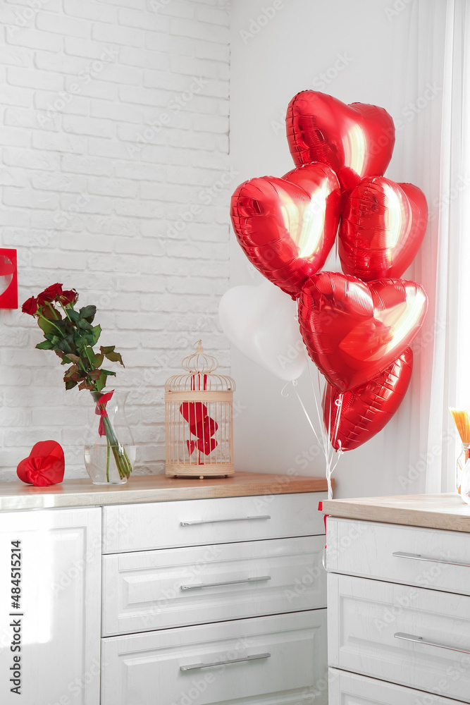 Counters with stylish decor and heart shaped air balloons for Valentines day celebration in kitchen