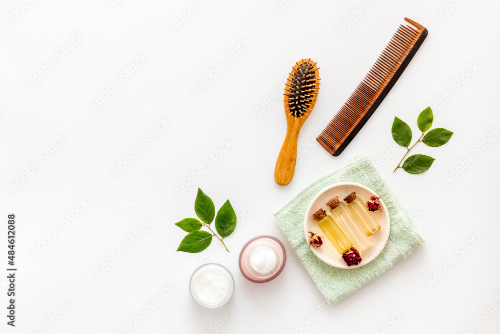 Flat lay of cosmetics for hair care with comb