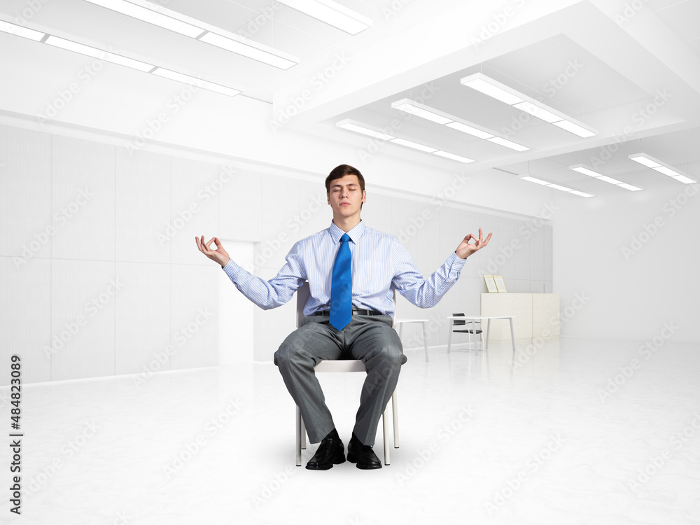 young businessman meditating in the office