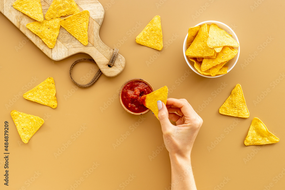 Mexican food nachos chips with tomato salsa sauce, top view