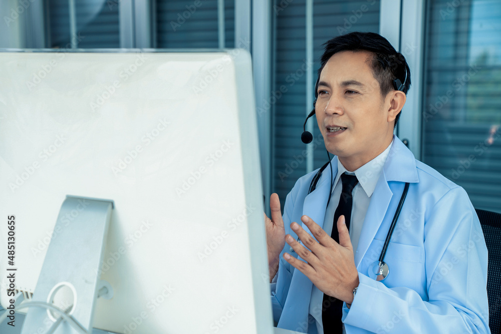 Doctor wearing headset talking actively on video call in a clinic or hospital . Concept of telehealt