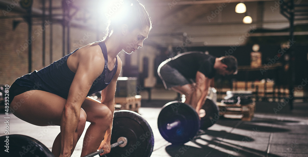 Sportive people holding barbells before doing deadlift