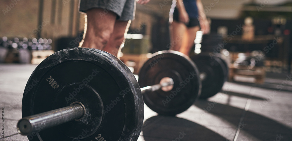 Man and woman going to lift barbells