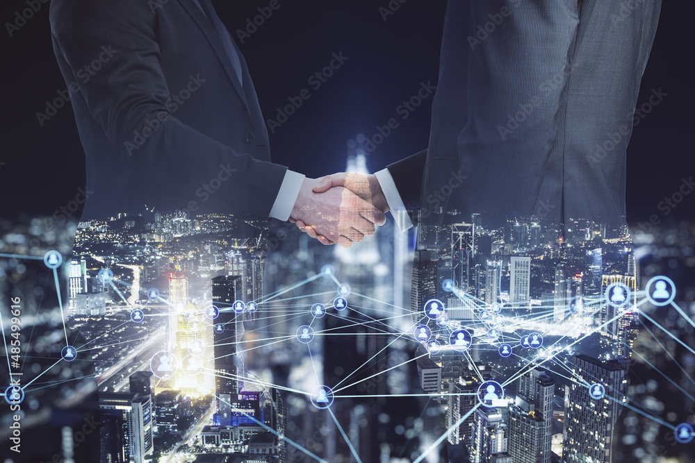 Abstract image of businesspeople shaking hands on blurry glowing polygonal network with people icons