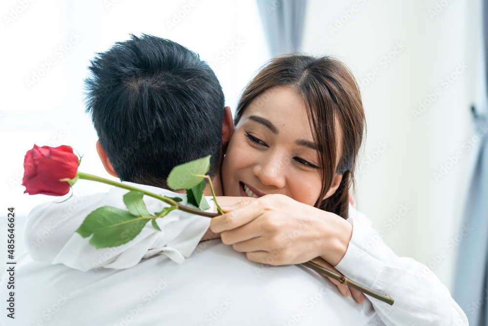 亚洲年轻人给漂亮的女朋友一个惊喜，送上玫瑰花。