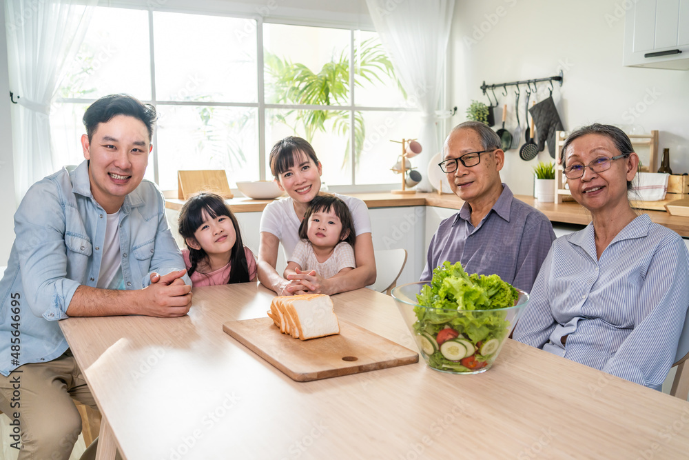 亚洲幸福大家庭在家里的餐桌上一起吃午饭。