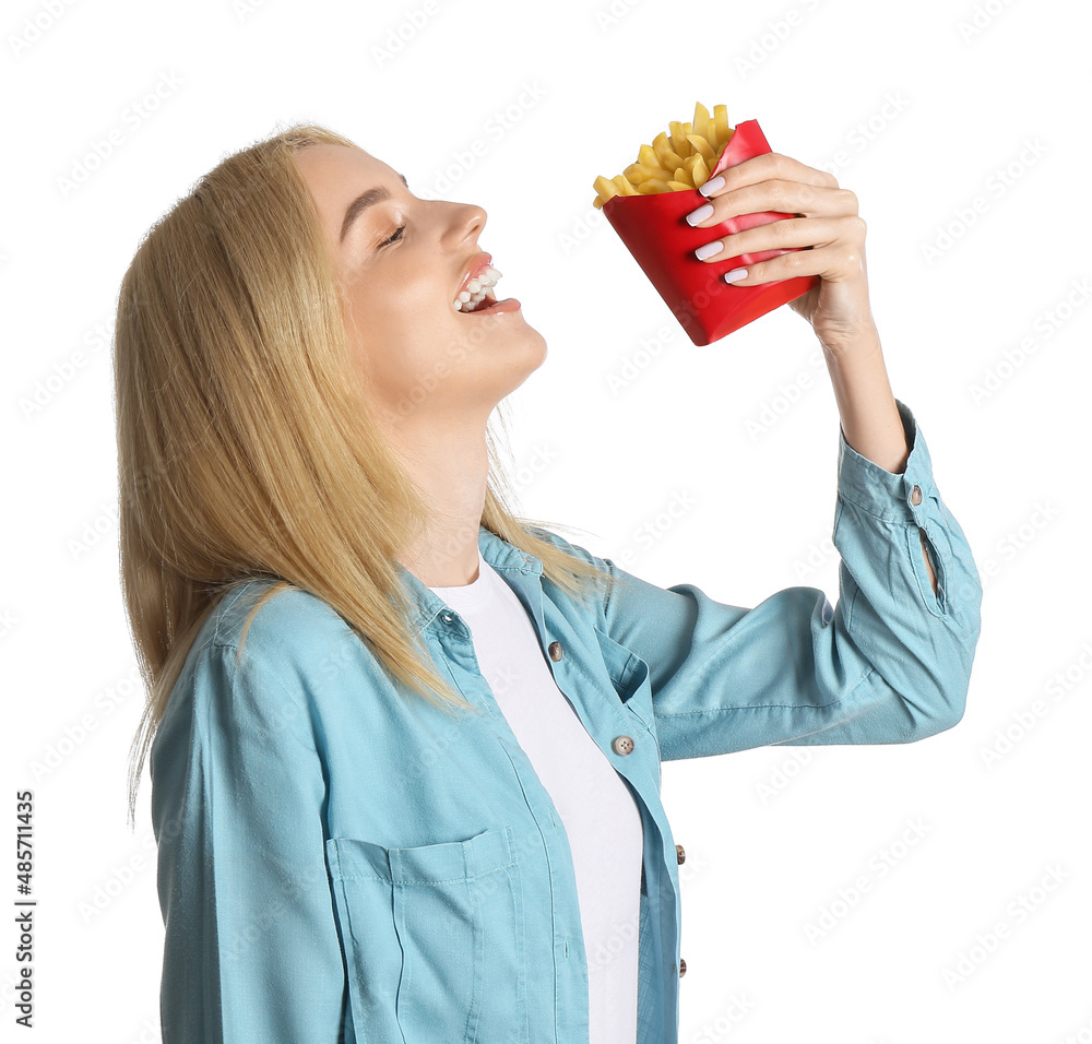 Young woman eating french fries on white background