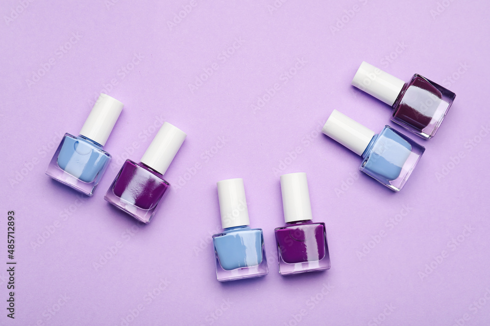 Set of nail polish bottles on color background