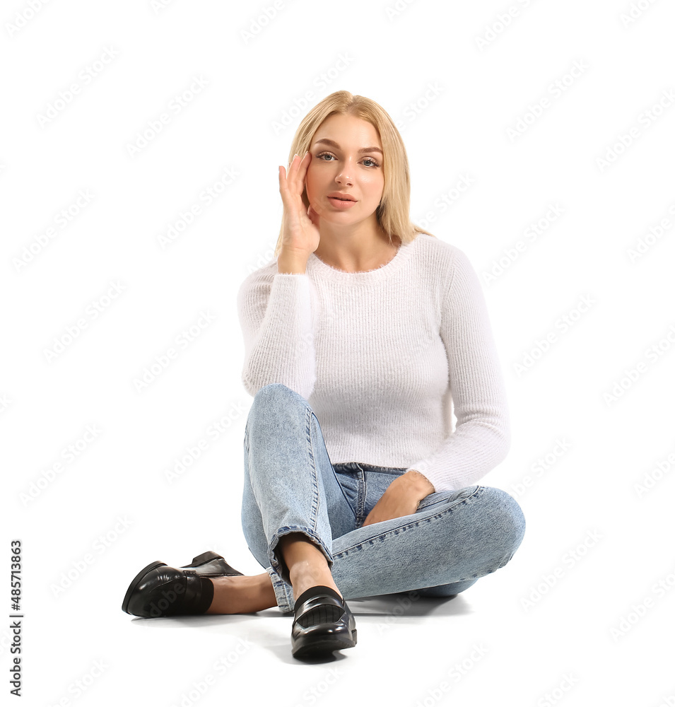 Fashionable young woman in stylish jeans on white background