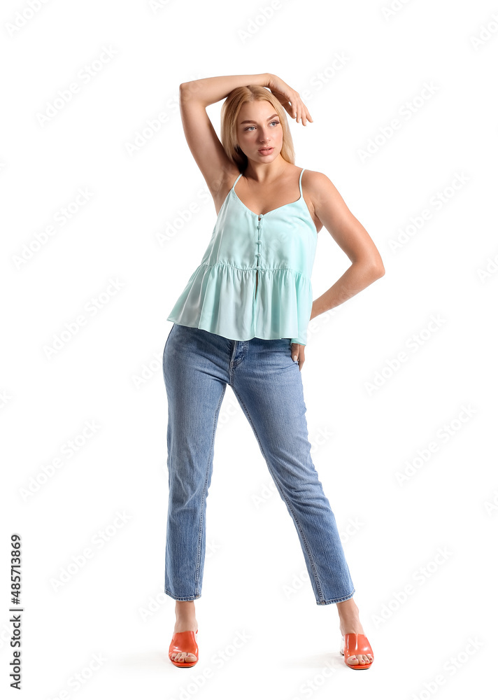 Fashionable young woman in stylish jeans on white background