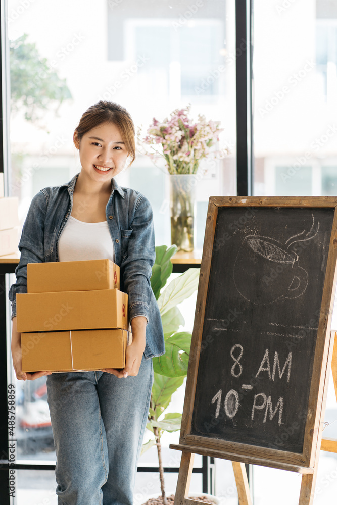 亚洲女性创业小企业主在工作场所打包纸板箱。自由职业女性卖家