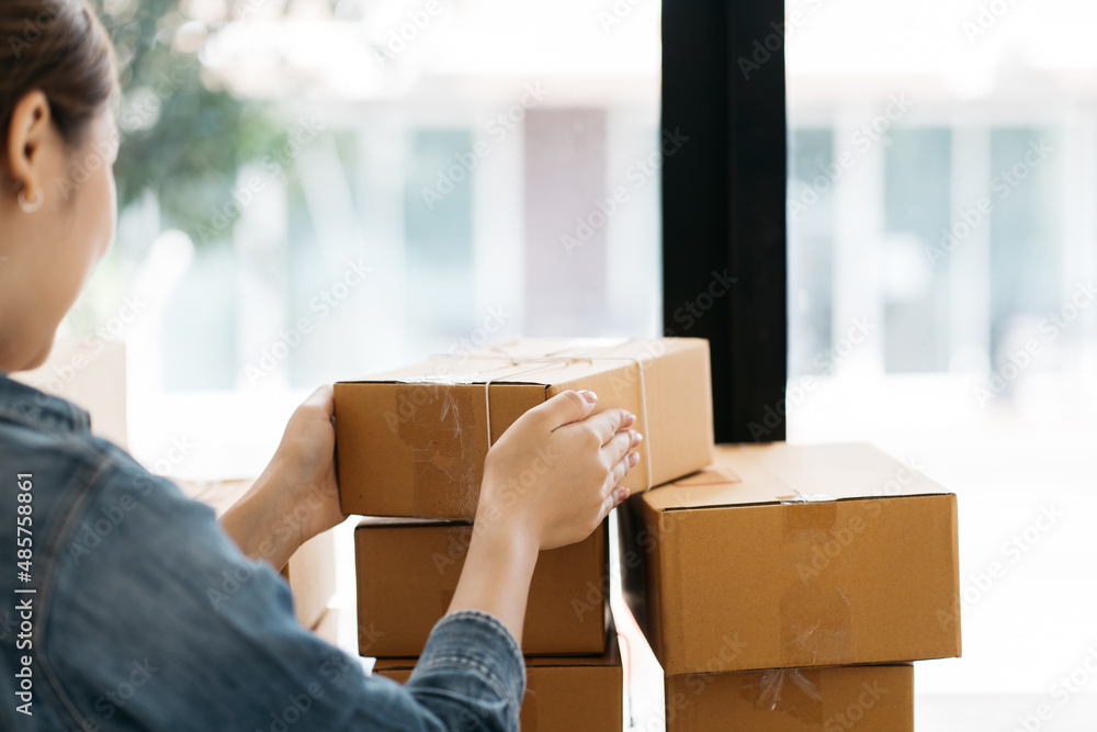 Asian woman start up small business owner packing cardboard box at workplace. freelance woman seller