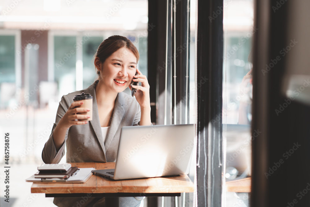 Young woman holding credit card and using laptop computer. Businesswoman working at home. Online sho