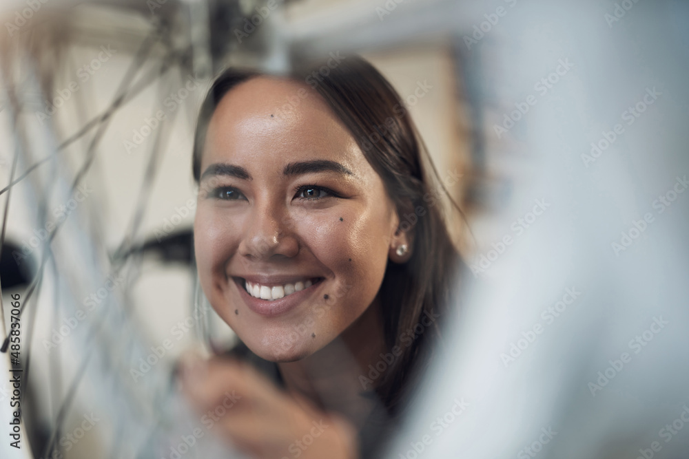 This looks as good as new. Shot of an attractive young woman crouching alone in her shop and repairi