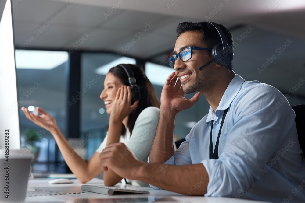 Call us anytime to get it done. Shot of a young man using a headset and computer in a modern office.