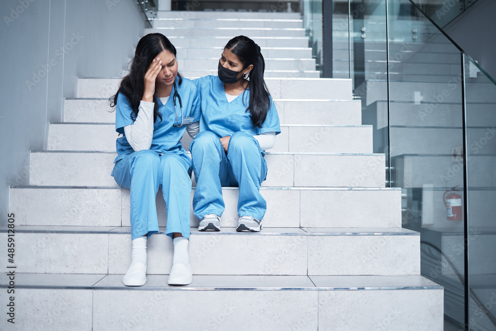 We did our best back there. Shot of a female nurse comforting her colleague while sitting on a stair