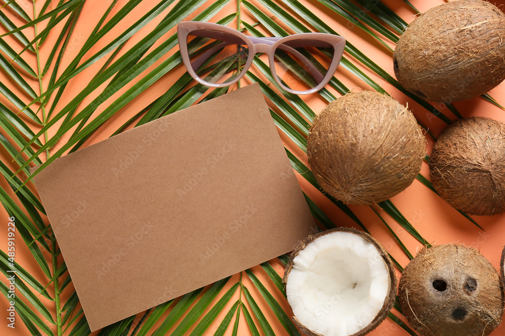 Composition with blank card, coconuts, palm leaves and sunglasses on color background