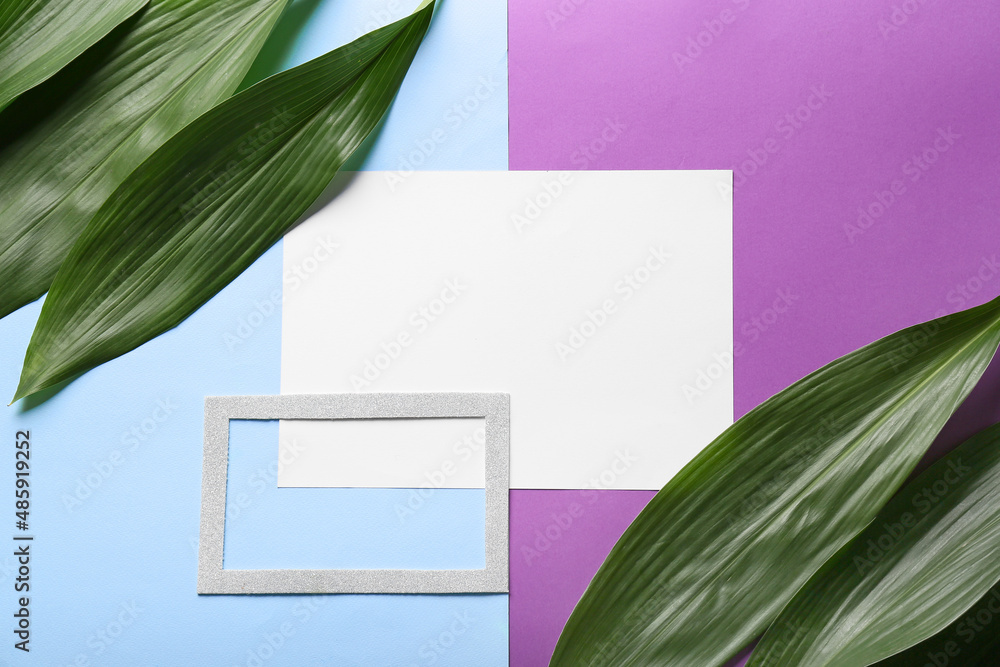 Composition with blank sheet of paper and plant leaves on color background