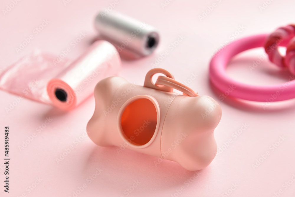 Dispenser for pet waste bags on pink background, closeup