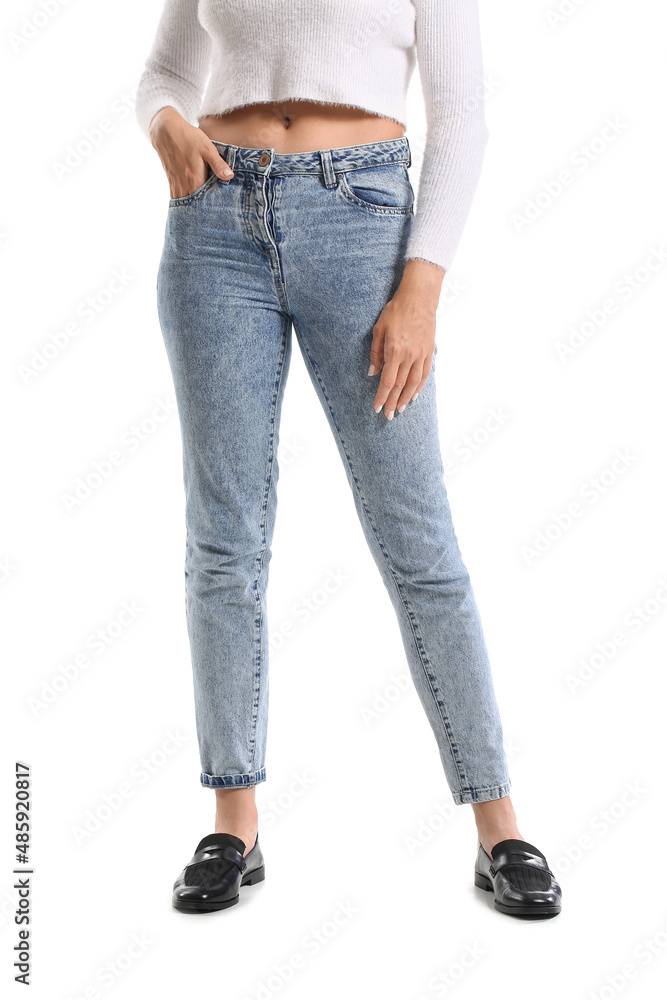 Fashionable young woman in stylish jeans on white background