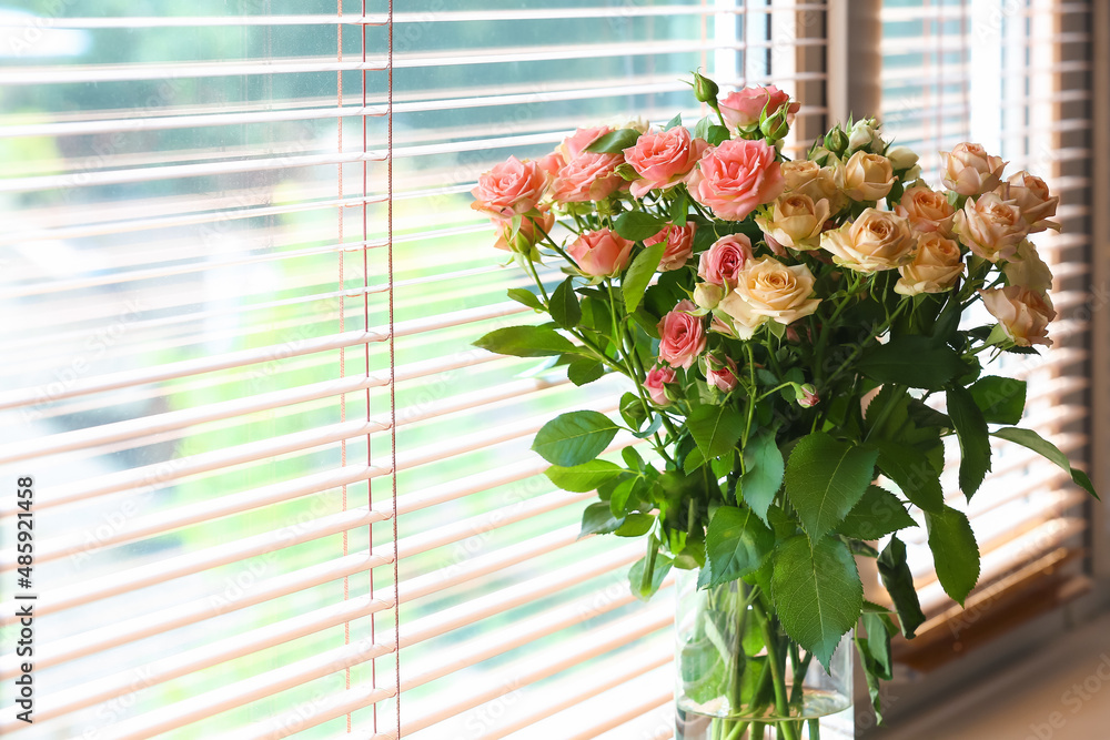 Vase with bouquet of beautiful fresh roses on windowsill, closeup