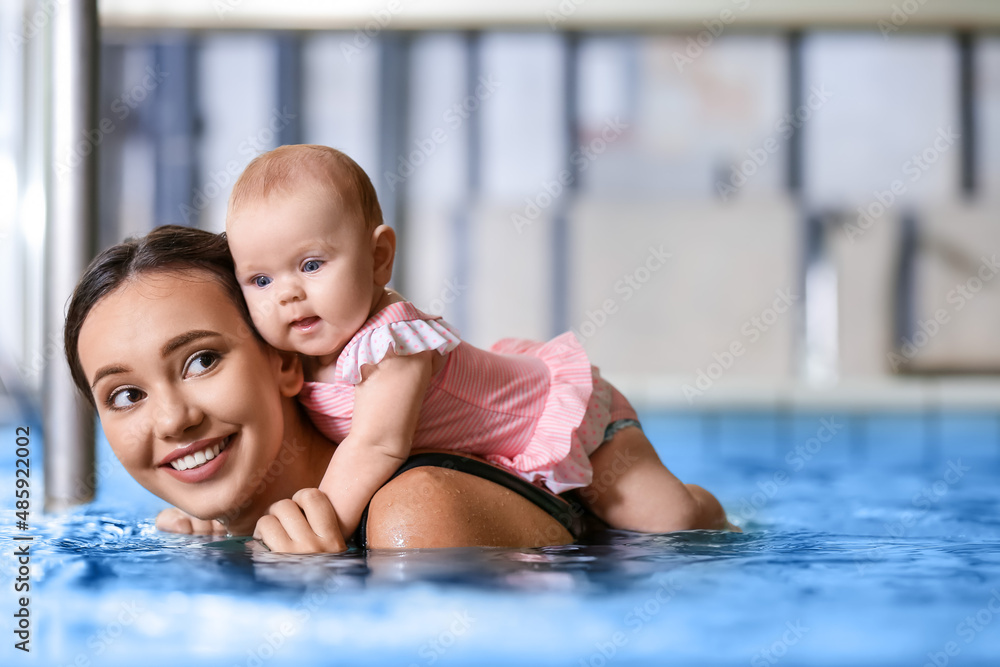 Young woman with her little baby in swimming pool