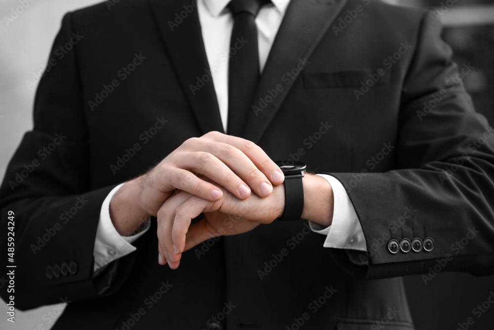 Stylish businessman using smartwatch outdoors, closeup