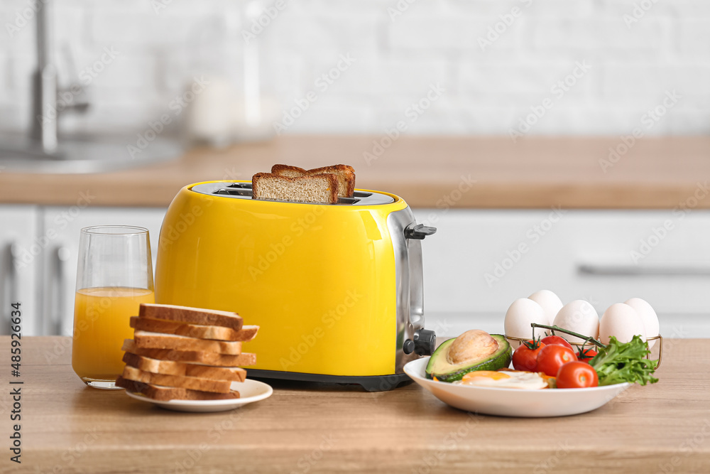 Yellow toaster with healthy food on table in modern kitchen