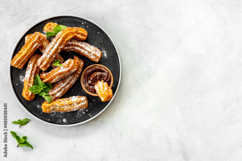 Churros fried pastry with chocolate sauce. Street food dessert