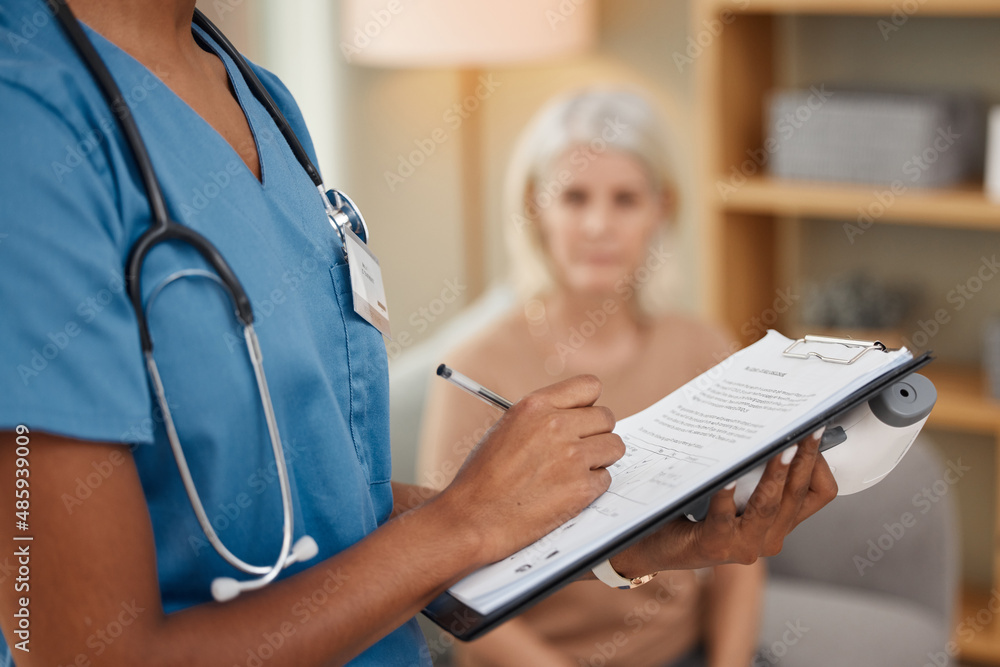 This doctor does home deliveries. Shot of a doctor filling out a questionnaire during a consultation