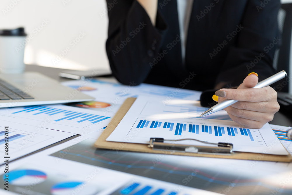 Businessman or accountant on office desk pointing at a paperwork is analyzing and auditing.