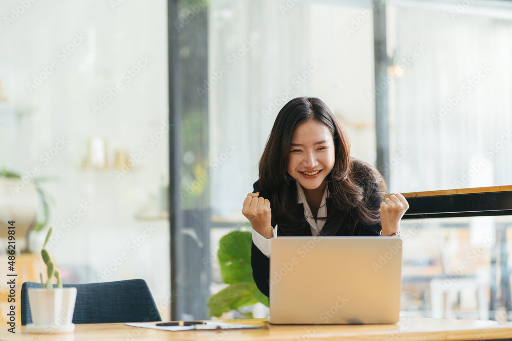 Excited Asian woman sit at desk feel euphoric win online lottery, happy black woman overjoyed get ma