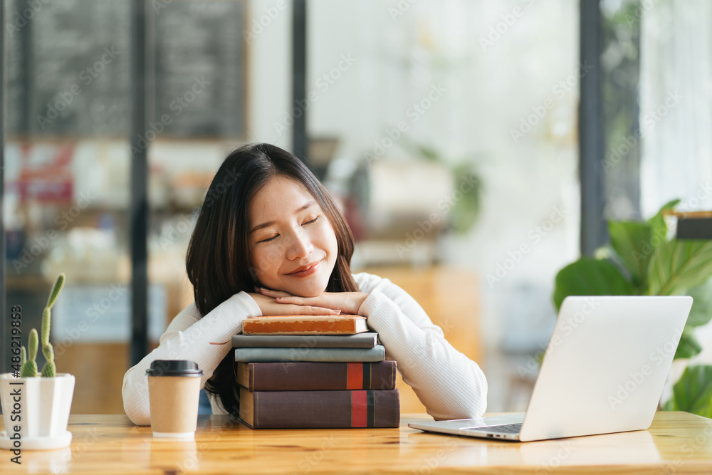 为大学入学做准备。一个疲惫的女孩在打开的一叠书上睡着了