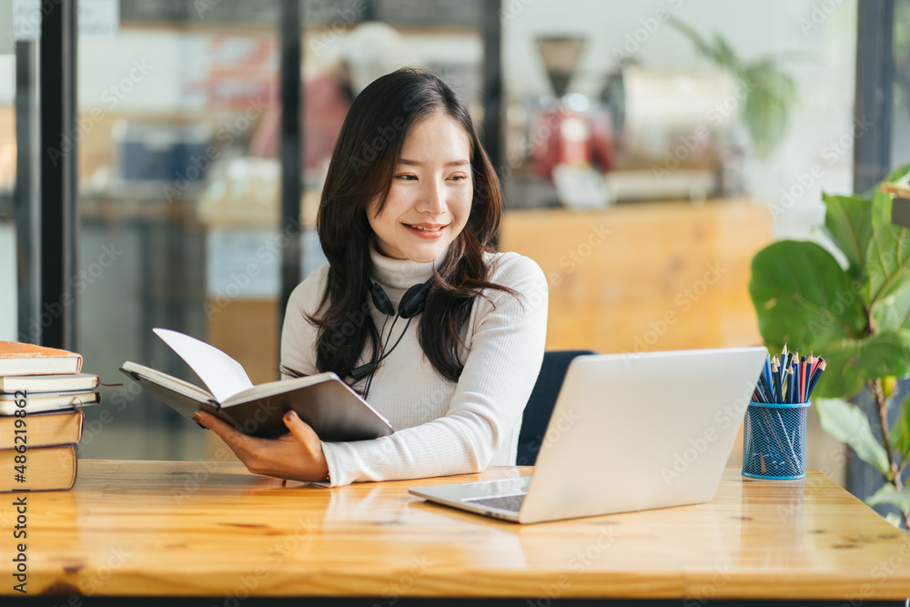 Image of young beautiful joyful woman smiling while working with laptop in office