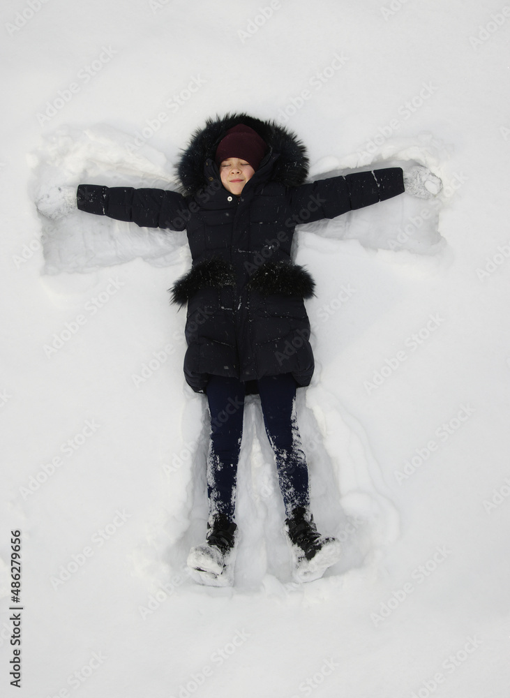 冬天躺在雪上的快乐女孩