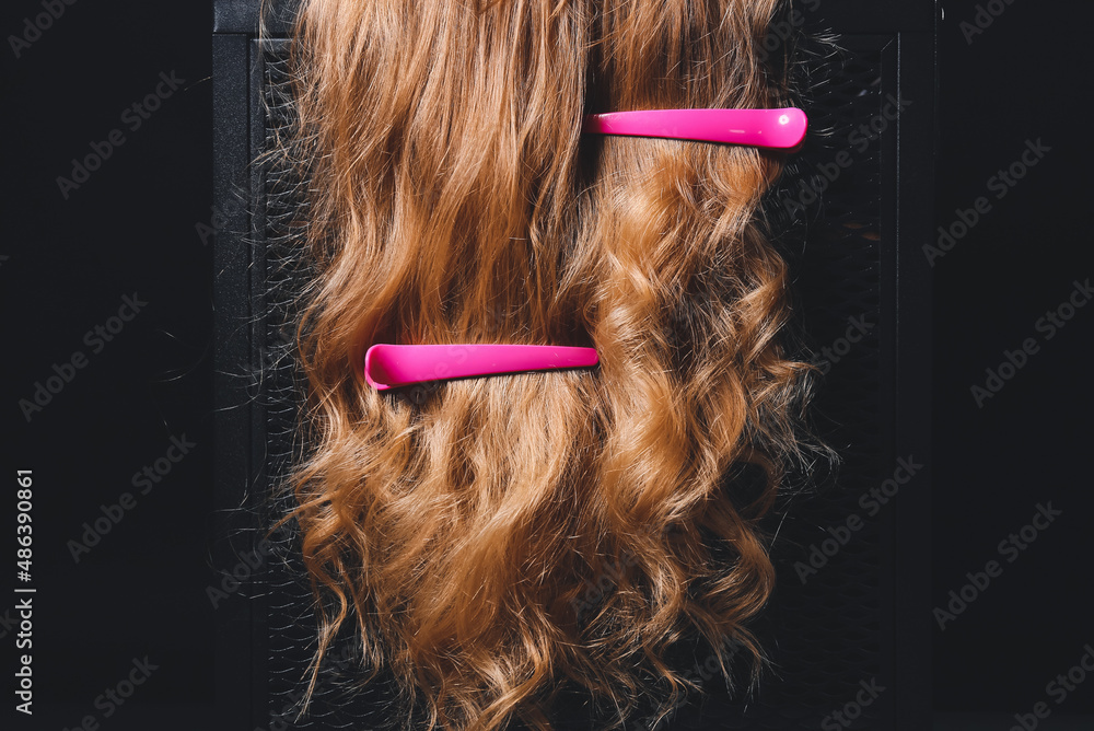 Woman with curly hair and hairpins on dark background