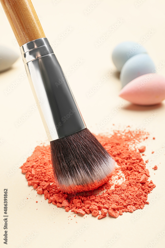 Makeup brush and loose eye shadow on light background