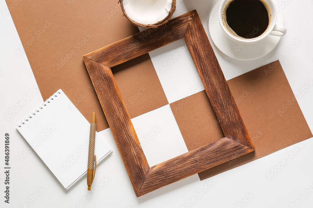 Composition with empty picture frame, cards, notebook and cup of coffee on white background