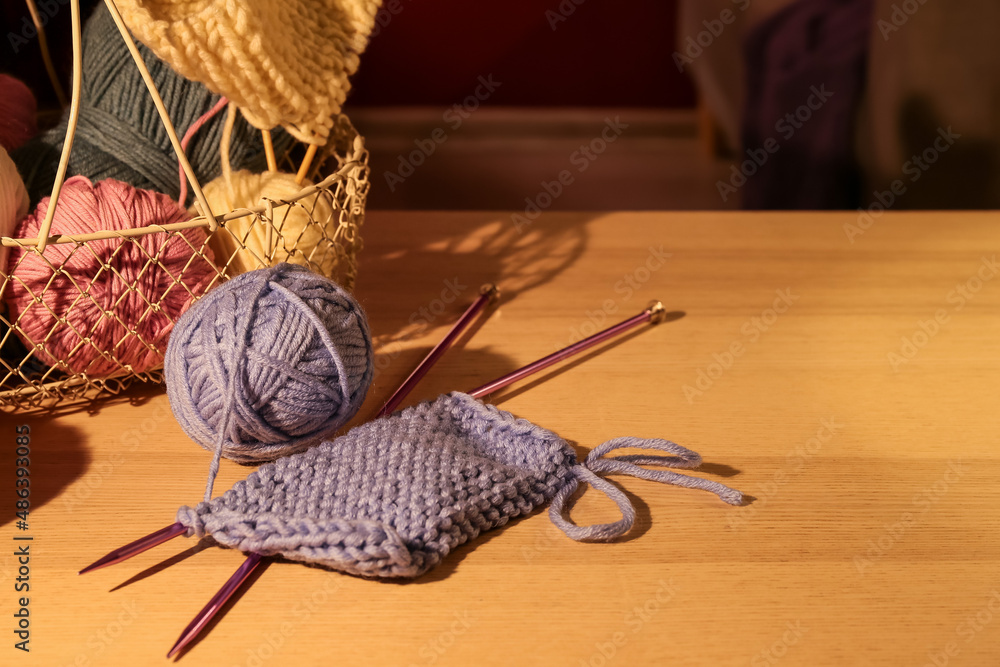 Knitting yarn and needles on wooden table