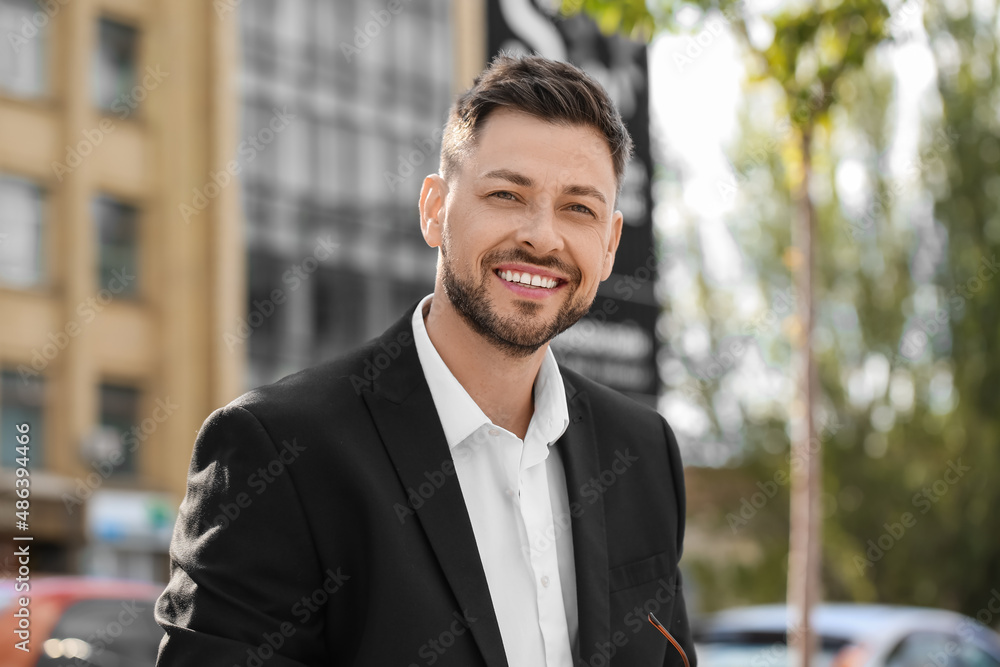 Stylish businessman smiling on city street