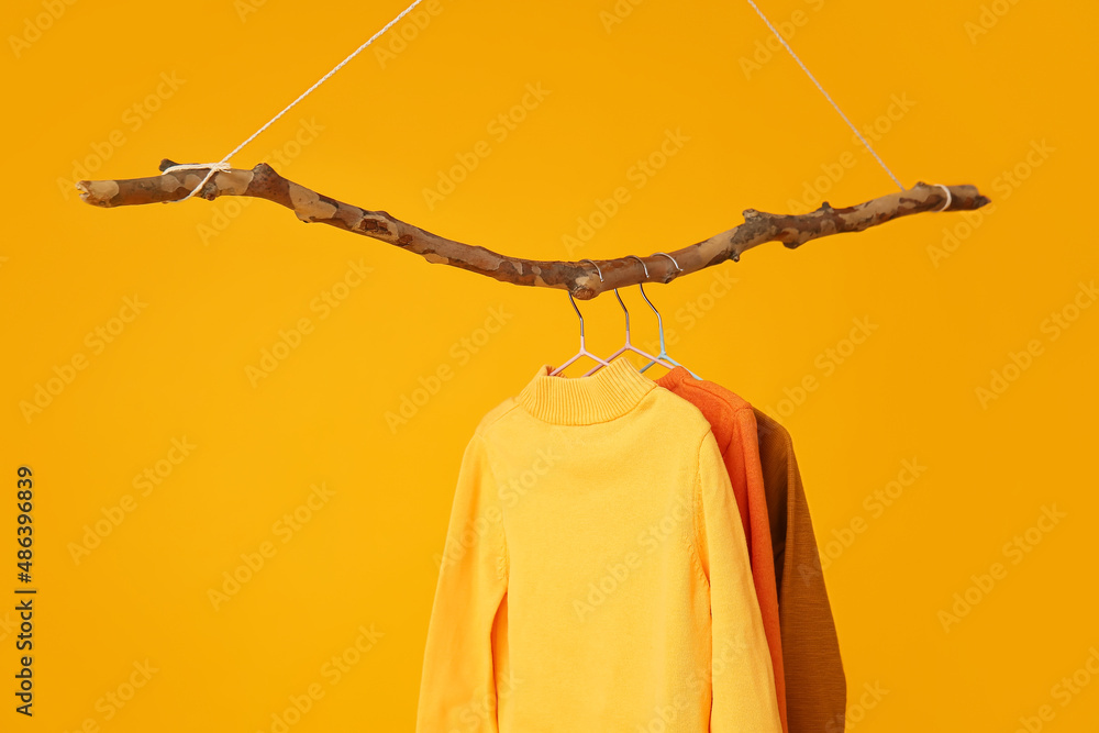 Different knitted sweaters on orange background