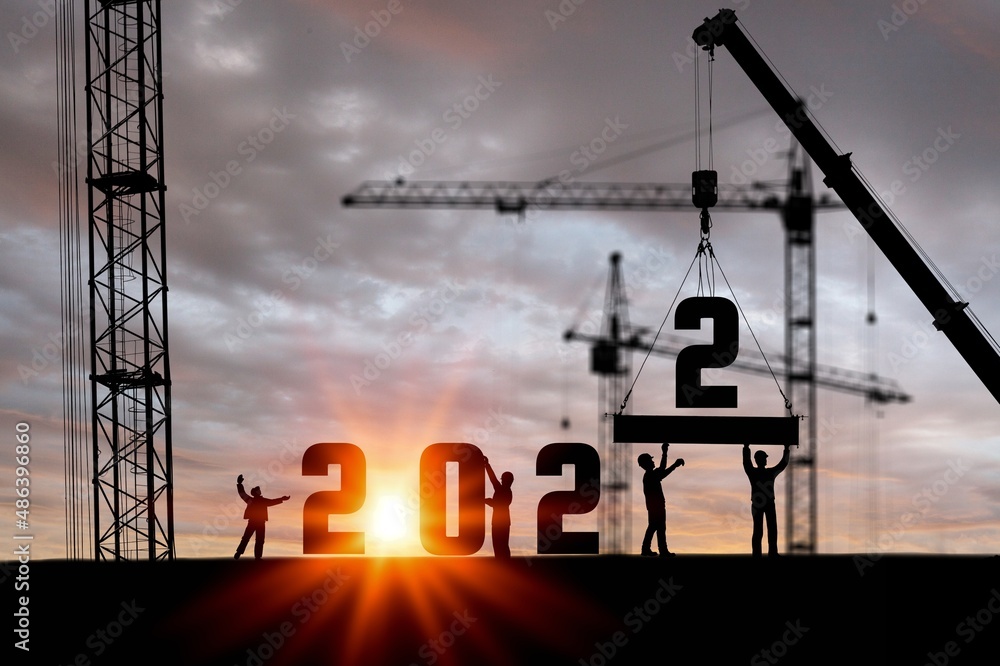 建筑工人用起重机和天空为迎接2022新年派对做准备的剪影