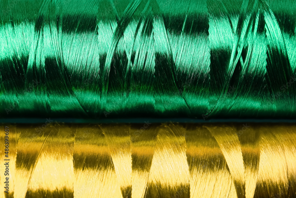 Spools with green silk sewing threads as background, closeup